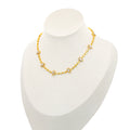 Almond choker by Selsela features a gold necklace adorned with small 
pearl-like beads and elegant paisley-shaped pendants, beautifully displayed on a white mannequin bust.