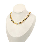The Neera Choker necklace , with its bold circular links, elegantly contrasts against a white mannequin bust from Selsela.